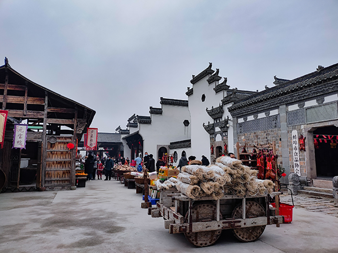 《年货一条街》摄影李文萍13705525255  拍于2023年元旦，蚌埠卫食园加工厂内“食品一条街”。   蚌埠卫食园，是远近闻名的食品加工厂。入冬以后，各种腌腊制品，销售至各大酒店和商场超市。打造出食匠村特色文化，现在是AAA级食品工业旅游景区。.jpg